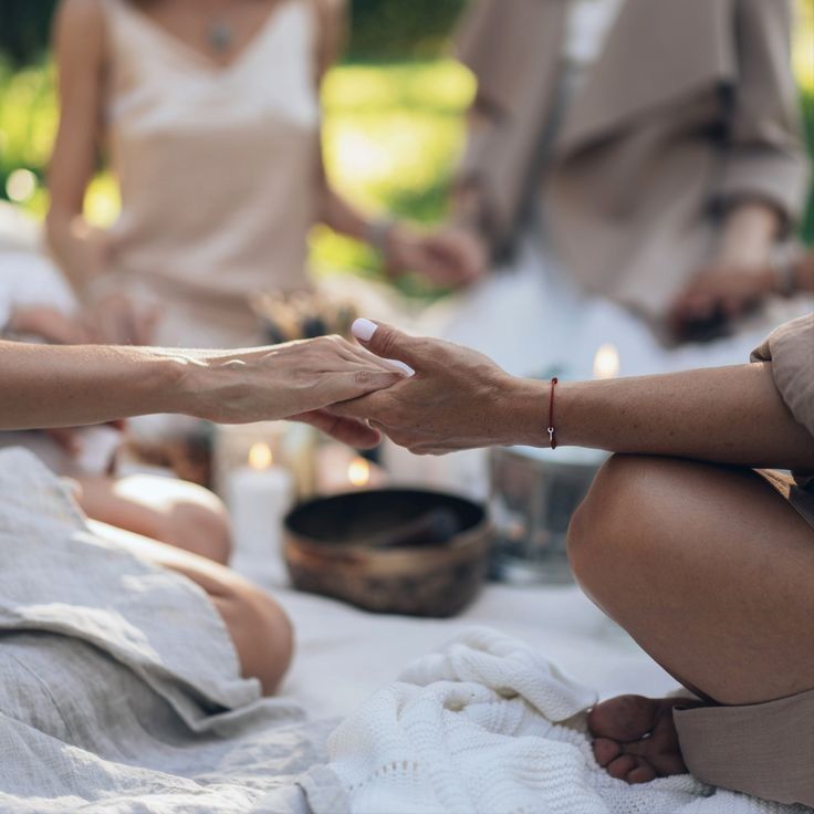 People holding hands together in an outdoor circle