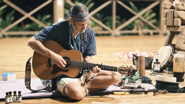 A musician playing guitar inside the pavilion
