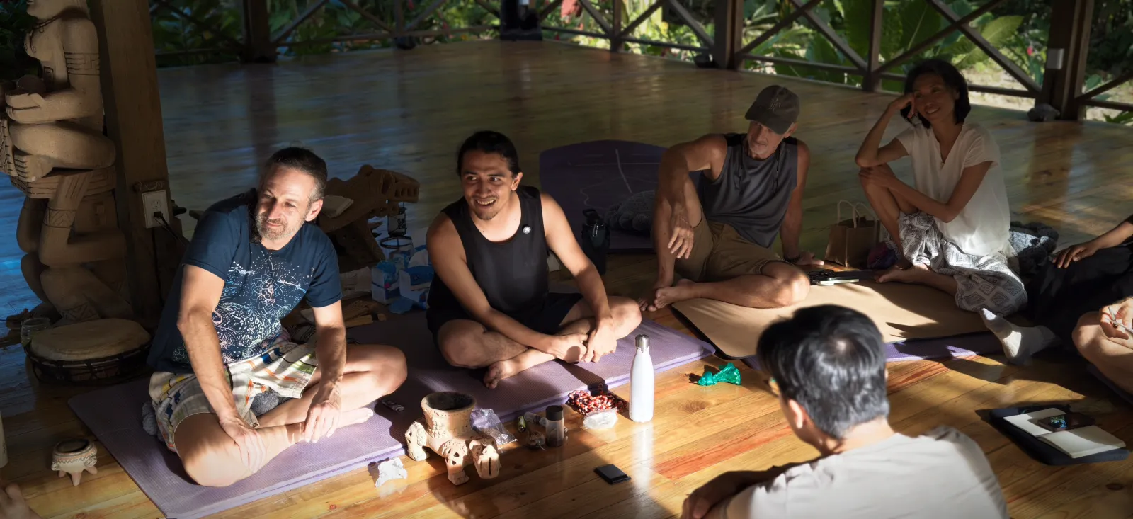 Participants sitting together and sharing reflections in the open-air pavilion